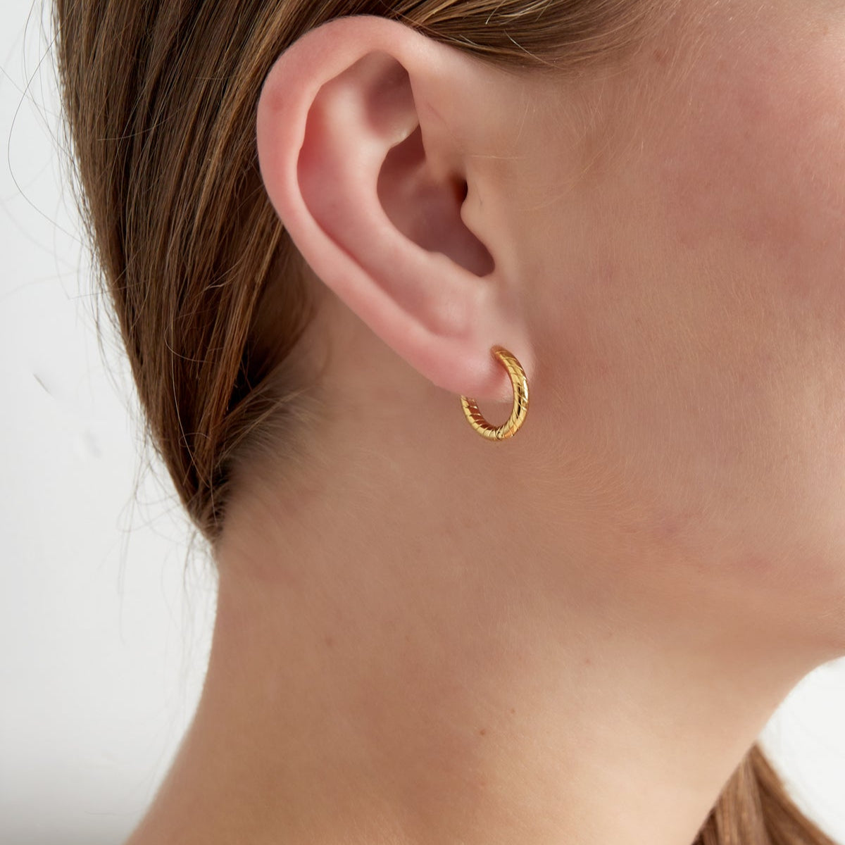 Hoops-örhängen i tvinnad design - Ringar i PVD guldpläterat kirurgiskt stål